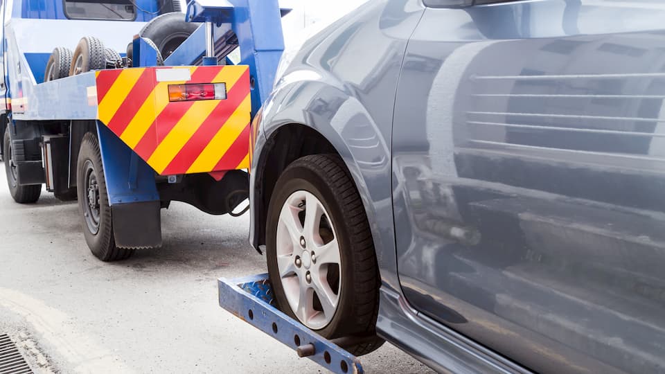 tow-truck-towing-a-broken-down-car-on-the-street